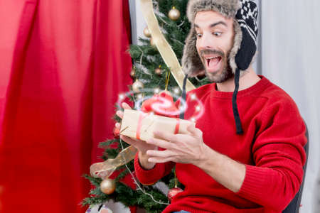Surprised man holding a magical Christmas giftの写真素材