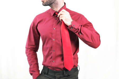 Businessman in red holding his tieの写真素材