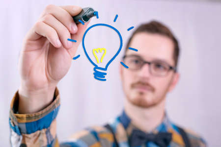 Idea man, drawing a light bulbの写真素材