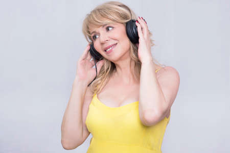 Blonde woman enjoying music over headphonesの写真素材