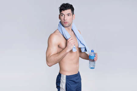 Sportsman after a workout holding a bottle of waterの写真素材