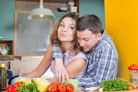 Happy couple eating in a kitchenの写真素材