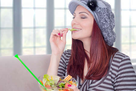 Redhead girl enjoying vegetable saladの写真素材