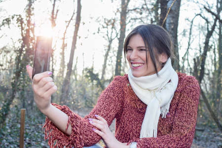 Girl in nature taking a selfieの写真素材