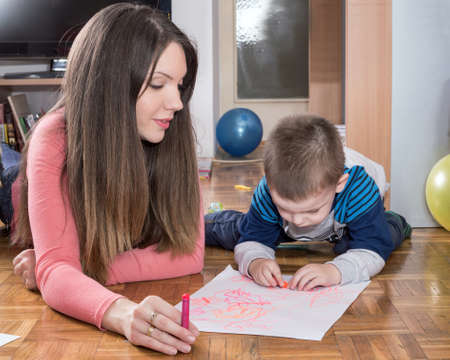 Mother and child drawing on the floorの写真素材