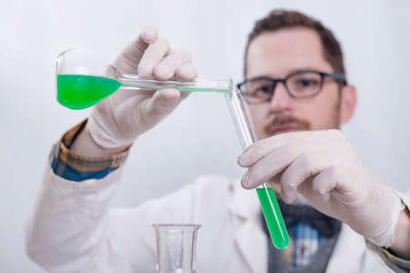 Scientist pouring liquids in a labの写真素材