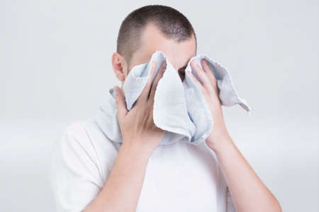 Man drying his face with a towelの写真素材