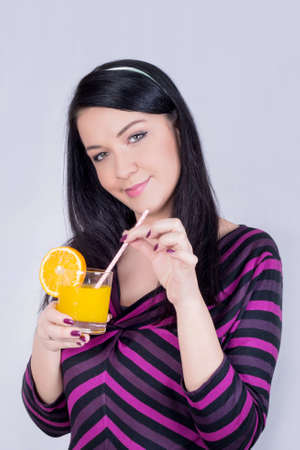 Healthy girl holding a glass of orange juiceの写真素材