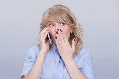 Surprised woman on a phoneの写真素材