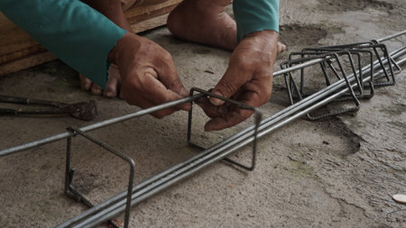 Worker welds steel structure at construction site, close-up