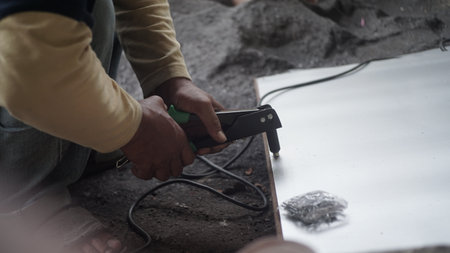 Construction worker using electric arc welding machine to weld iron at construction site.の写真素材