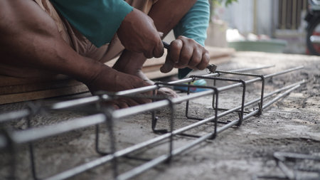 construction worker installing steel reinforcement bar on concrete floor at construction siteの写真素材