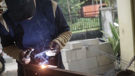Welding work with arc welding machine to weld steel at factoryの写真素材