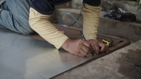 Worker working on laminate flooring at a construction site.の写真素材