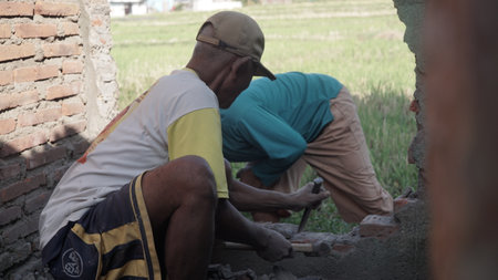 Workers are building a brick wall at a construction site in Thailand.の写真素材