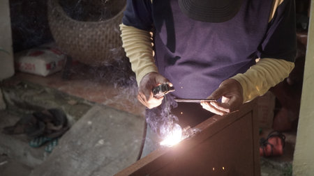 Worker welds metal at a construction site, close-up