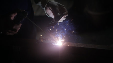 welder at work with protective mask and sparks, close-upの写真素材