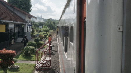 Train passing through a rural area with green trees and shrubs.の写真素材