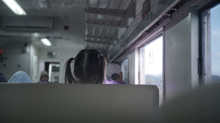 Back view of a girl riding a train. View from inside the train.の写真素材