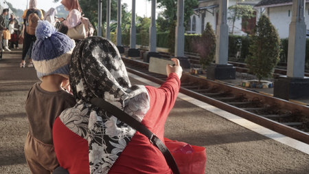 Asian muslim woman with hijab sitting on the platform of the railwayの写真素材