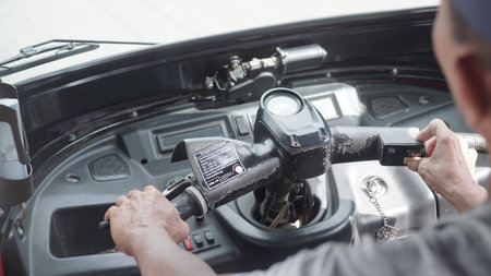 Close-up of a man's hands holding a steering wheel.の写真素材