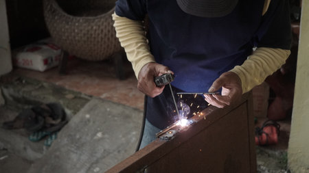 Welding work in the workshop. The welder welds a metal product.