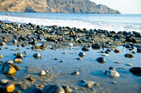 close-up stones at the beach at sunset with the sea in the backgroundの写真素材