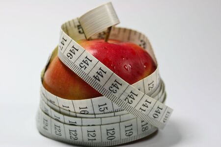 This is a shot of apple with some tailor meter around the apple.