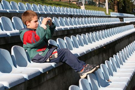 young photographer sitting in the stands and photograph gameの写真素材