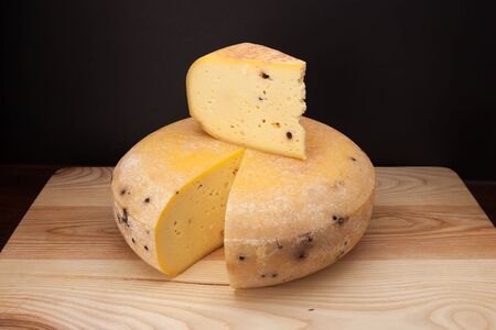 A piece of cheese on a wooden tableの写真素材