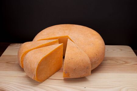 A piece of cheese on a wooden tableの写真素材