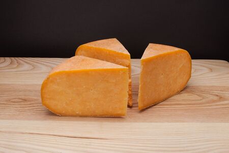 A piece of cheese on a wooden tableの写真素材