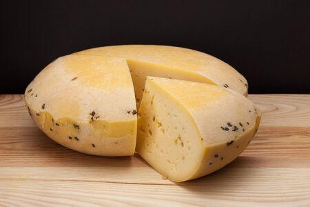 A piece of cheese on a wooden tableの写真素材