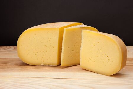 A piece of cheese on a wooden tableの写真素材