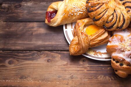 Sweet buns on a plate on the wooden tableの写真素材