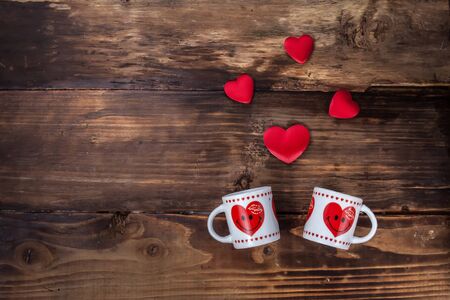 2 cups with hearts and a hearts on a wooden tableの写真素材
