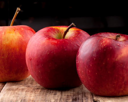 Red apples on a dark wooden tableの写真素材