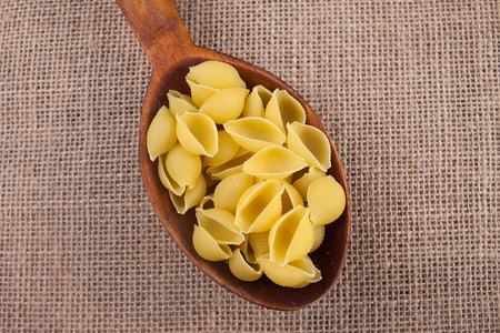 pasta macaroni in a spoon on a textureの写真素材