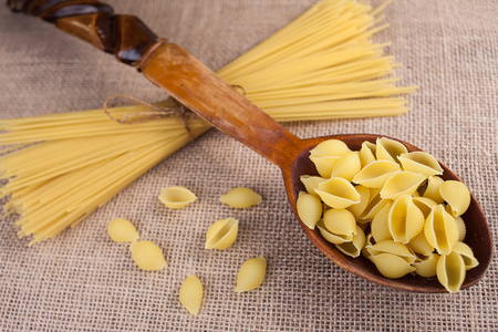 pasta macaroni in a spoon on a textureの写真素材