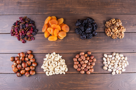 Different kinds of nuts and dry fruits on the wooden tableの写真素材