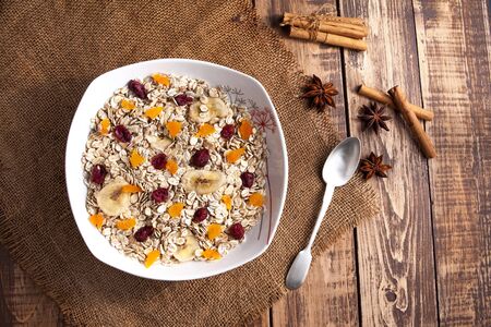 A plate with oats and dry fruits on wooden tableの写真素材