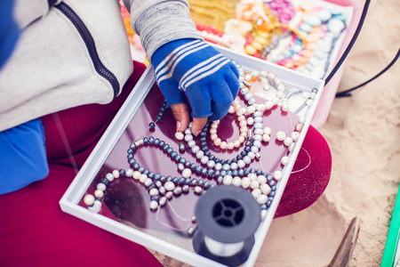 Handmade jewelry making Woman creating bracelet outdoorの写真素材