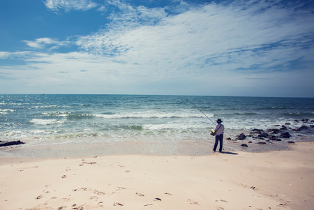 fisherman fishing in the beach sunny dayの写真素材