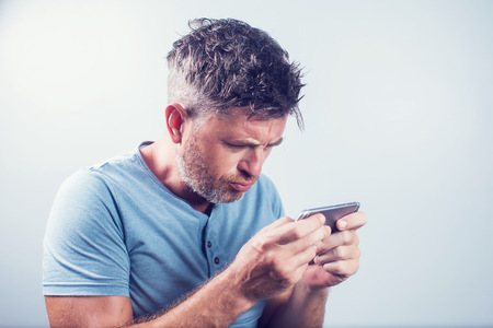 Handsome young man using mobile phone isolated