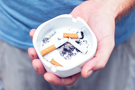 White ceramic ashtray full of smokes cigarettesの写真素材