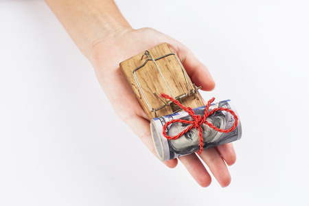 Money in a mousetrap with a hand. On a white background.の写真素材
