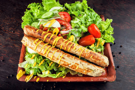 Grilled sausage with vegetables and mostard on wooden boardの写真素材