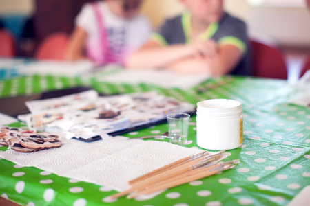 Paint brushes and crafting supplies on the table in a workshop.