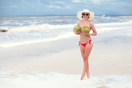 Happy young woman in straw hat with on the beachの写真素材