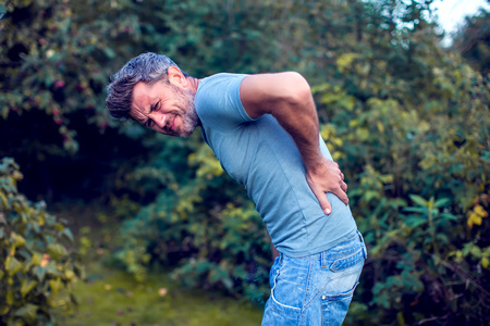 Medical, healthcare and problem concept. Unhappy man suffering from backache, spinal injury and...